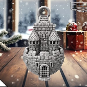 Può includere: Un ornamento di castello in pietra grigia con un anello in cima per appenderlo. Il castello ha due torri e un cancello. L'ornamento ha la forma di una sfera.