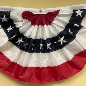 May include: A red, white, and blue pleated fabric bunting with stars. The bunting is shaped like a half-circle and is decorated with white stars on a blue background.