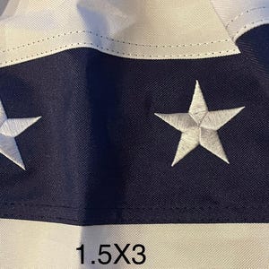 Puede incluir: Primer plano de una secci&oacute;n de bandera con estrellas blancas sobre fondo azul marino, alternando con rayas blancas y rojas. El texto "1.5X3 600D heavy synthetic" es visible.