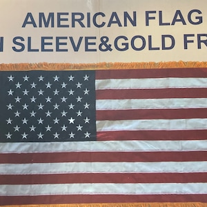 K&ouml;nnte beinhalten: Amerikanische Flagge mit goldener Franse und einem &Auml;rmel. Die Flagge hat 48 Sterne.