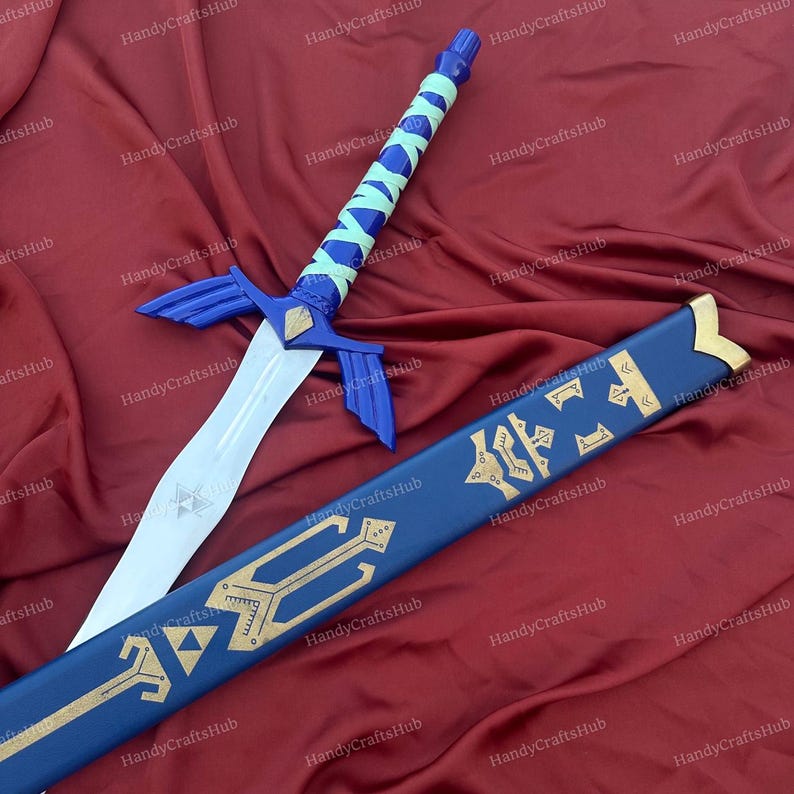 Puede incluir: Una espada de fantas&iacute;a azul y plateada con una hoja blanca y una vaina azul a juego. La espada presenta una empu&ntilde;adura azul con un agarre envuelto en verde claro. La vaina es azul con elementos decorativos dorados.