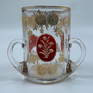 Kristall med 3 handtag och ovala rubinfärgade paneler med graverade blommor och graverade blommor runtom, konturerad med guld, kant och linjer Becher