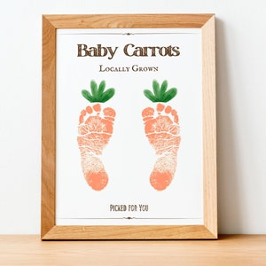 Può includere: Una stampa incorniciata con il testo "Baby Carrots Locally Grown" e due impronte di piedi arancioni con cime verdi, che ricordano le carote. Il testo "Picked for You" è in fondo alla stampa.