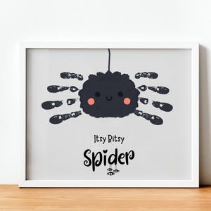 Pode incluir: Uma impressão emoldurada com uma ilustração de aranha caprichosa. A aranha é cinza escuro com pernas em forma de pegadas de mãos e bochechas rosadas. O texto "Itsy Bitsy Spider" está escrito abaixo em uma fonte lúdica.