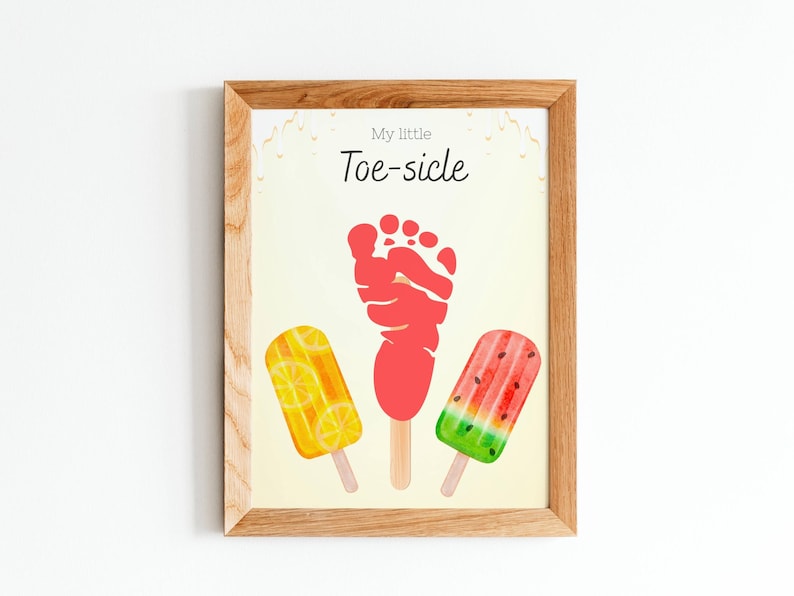 May include: Wooden framed print with the text "My little Toe-sicle". The artwork features a red footprint and three popsicle illustrations: lemon, a red popsicle, and watermelon. The background is a light yellow.