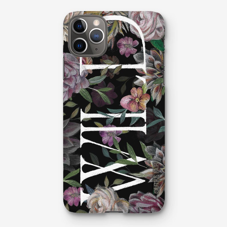 May include: A black phone case with a floral pattern and the word "WILD" in white lettering. The flowers are in shades of pink, purple, and green. The case is designed for an iPhone.