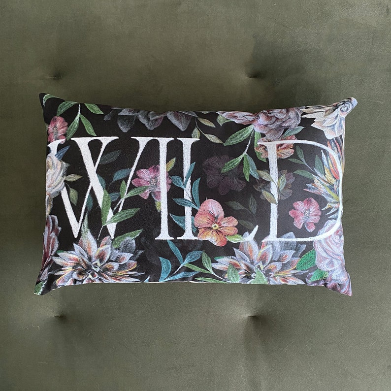 May include: A black pillow with a floral pattern and the word "WILD" printed in white.