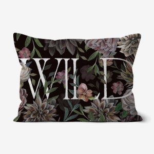 May include: A black pillow with a floral pattern and the word "WILD" in white lettering.