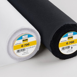 May include: Two rolls of fabric, one white and one black, are displayed. Each roll has a yellow and blue label that reads "G 700" and "90 cm x 25 m". The fabric is 100% CO.