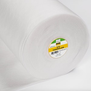 Peut inclure: Un rouleau blanc de tissu thermocollant 272 ThermOlam. L'étiquette est jaune avec du texte noir et un logo vert. L'étiquette indique "272 ThermOlam 100% PES 90 cm x 25 m".