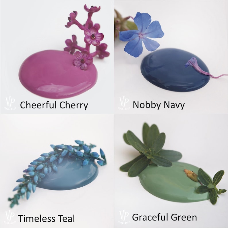 K&ouml;nnte beinhalten: Vier Farbmuster mit Blumenakzenten. Die Farben sind Cheerful Cherry, ein kr&auml;ftiges Pink, Timeless Teal, ein Blaugr&uuml;n, Nobby Navy, ein Dunkelblau, und Graceful Green, ein gedecktes Gr&uuml;n.
