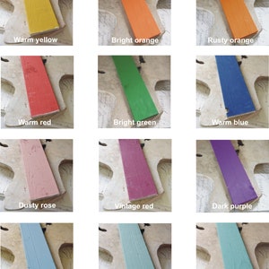 K&ouml;nnte beinhalten: Eine Sammlung von 12 Farbmuster auf Holzbrettern. Die Farben umfassen warmes Gelb, leuchtendes Orange, Rostorange, warmes Rot, leuchtendes Gr&uuml;n, warmes Blau, staubiges Rosa, Vintage-Rot, Dunkelviolett, staubiges Blau, staubiges T&uuml;rkis und altes T&uuml;rkis.