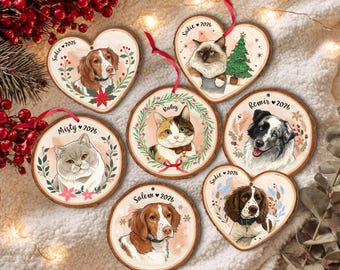 May include: A collection of six wooden ornaments featuring custom pet portraits and the year 2026. The set includes heart-shaped and circular wood slices decorated with illustrations of dogs and cats, each personalized with names like Sadie, Ruby, Misty, Remir, and Salem.