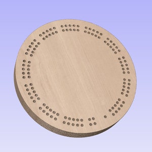 May include: A circular wooden cribbage board, featuring a light brown colour and a series of small holes. These holes are arranged in a circular pattern around the board's edge and centre. The board is likely made from a single piece of wood.