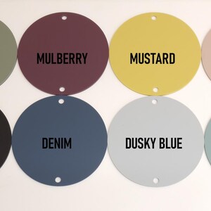 K&ouml;nnte beinhalten: Acht runde Farbmuster in verschiedenen Farben, darunter Kiefer, Maulbeere, Senf, staubiges Rosa, Schwarz, Denim, staubiges Blau und Entenei.
