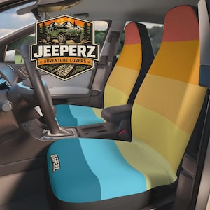 May include: Car seat covers with a gradient design in shades of yellow, orange, and blue. The covers are installed in a vehicle. The logo "Jeeperz Adventure Covers" is visible on the seat and in the upper left corner.
