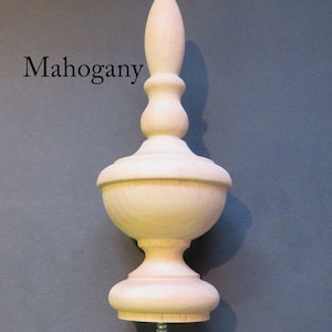 May include: A light wood finial with a bulbous shape and a pointed top. The finial has a screw on the bottom. "Mahogany" is written in black text on the left side of the image.