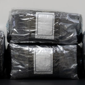 May include: Four sealed packages of black tea leaves, each with a white label.