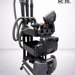 Könnte beinhalten: Ein schwarzes NC-3D CleanStation mit mehreren Schläuchen, Düsen und einer Ablage. Der Wagen hat Räder und ist kompatibel mit Hyla EST. Das NC-3D-Logo ist oben rechts sichtbar.