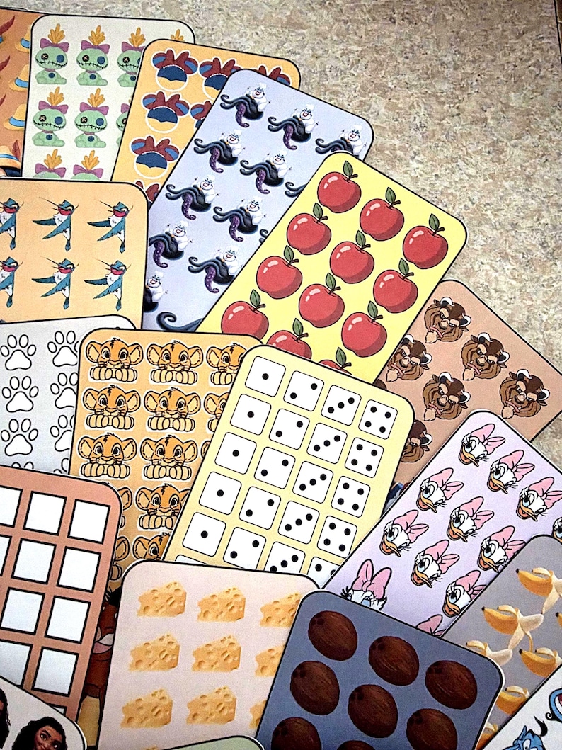K&ouml;nnte beinhalten: Eine Sammlung farbenfroher, rechteckiger Aufkleber mit verschiedenen Designs. Die Aufkleber zeigen Bilder von &Auml;pfeln, W&uuml;rfeln, Zeichentrickfiguren, Pfotenabdr&uuml;cken und anderen Mustern. Die Aufkleber sind f&auml;cherf&ouml;rmig angeordnet.