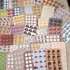 K&ouml;nnte beinhalten: Eine Sammlung bunter, rechteckiger Aufkleber mit verschiedenen Designs, darunter Zeichentrickfiguren, Muster und Lebensmittel. Die Aufkleber zeigen Bilder von &Auml;pfeln, W&uuml;rfeln und Disney-Figuren. Einige Aufkleber haben Text unten.