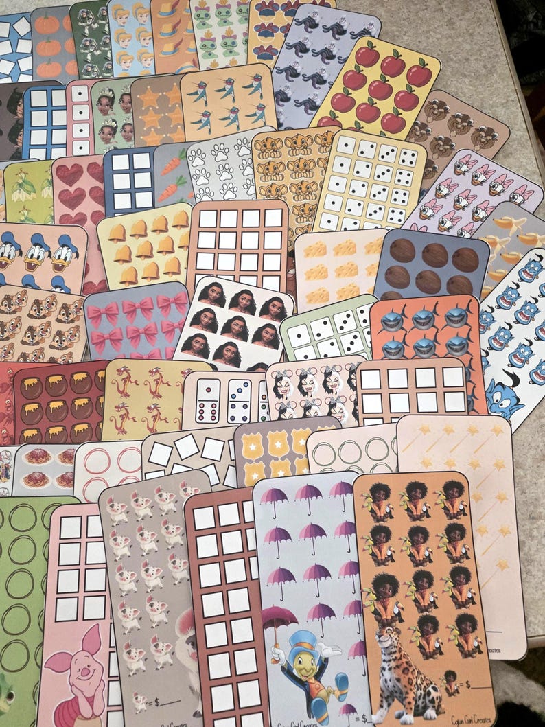 K&ouml;nnte beinhalten: Eine Sammlung bunter, rechteckiger Aufkleber mit verschiedenen Designs, darunter Zeichentrickfiguren, Muster und Lebensmittel. Die Aufkleber zeigen Bilder von &Auml;pfeln, W&uuml;rfeln und Disney-Figuren. Einige Aufkleber haben Text unten.