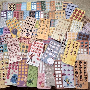 May include: A collection of colorful sticker sheets featuring various designs. The stickers showcase Disney characters, patterns, and other illustrations. The sheets are rectangular and arranged in a scattered display, with a variety of colors and themes.