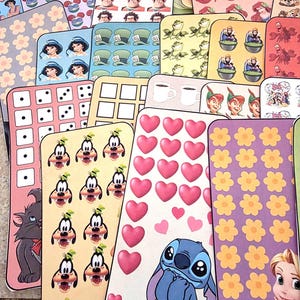 K&ouml;nnte beinhalten: Eine Sammlung farbenfroher, rechteckiger Aufkleber mit verschiedenen Zeichentrickfiguren und Mustern. Designs umfassen Disney-Charaktere wie Stitch, Goofy und Prinzessinnen sowie Blumen- und Herzmuster. Jeder Aufkleber hat einen Platz f&uuml;r einen Geldbetrag und den Text "Cajun Girl Creates".