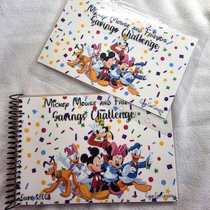 May include: Two savings challenge notebooks featuring Mickey Mouse and Friends characters. The notebooks have a white background with colorful confetti and the text "Mickey Mouse and Friends Savings Challenge". One notebook is spiral-bound and says "Save $800".