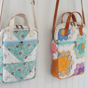 May include: Two quilted fabric shoulder bags with floral patterns. One bag features turquoise and white floral triangles, a light blue zipper, and a cream-colored handle. The other bag has a brown leather handle and base, with colorful floral patches.