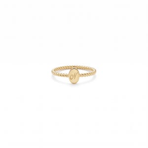 May include: A gold ring featuring a twisted rope-style band and a central oval-shaped plaque. The plaque is engraved with the cursive letter N in the centre. The ring has a polished metallic finish and a consistent yellow gold colour throughout.