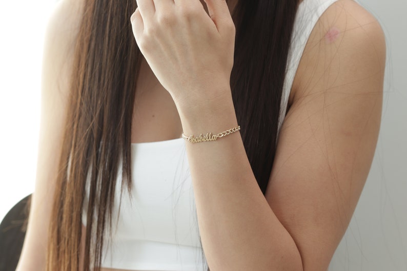 以下が含まれることがあります： イザベラという名前が筆記体で書かれた、金のチェーンブレスレットです。