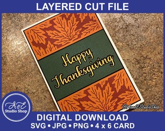 Pode incluir: Um download digital de um arquivo de corte em camadas para um cartão de Ação de Graças. O cartão apresenta um fundo verde com o texto "Happy Thanksgiving" em amarelo. O cartão é decorado com folhas laranja e marrons.