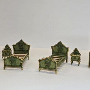 May include: Miniature bedroom furniture set in a classic style. The set includes a chest of drawers, two beds, two bedside tables, and a tall cabinet. The furniture is painted green with gold accents.