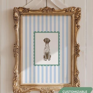 May include: A gold framed print with a blue and white striped background. The print features a green border with a black and white illustration of a dog sitting. The text "CUSTOMIZABLE" is printed below the frame.