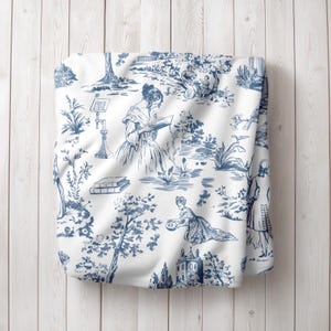 May include: White fabric with a blue toile pattern featuring a repeating design of people in a garden setting. The pattern includes trees, flowers, and a small house.