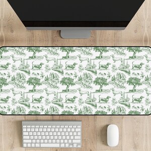 May include: A white and green desk mat with a repeating pattern of dachshunds and trees. The dachshunds are in various poses, including walking, sitting, and lying down. The trees are green and have a simple, stylized design.