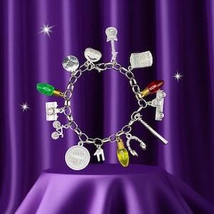 May include: A silver charm bracelet featuring a variety of charms, including a light bulb, a bicycle, a camera, a guitar, a computer, a Christmas light, a horseshoe, a house, and a charm with the text "Stranger Things Don't Lie".