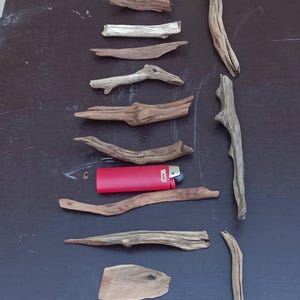 May include: A white ceramic mug with a black handle and the text "But First, Coffee" in a bold, black font. The mug is set against a blurred background, suggesting a cozy setting.