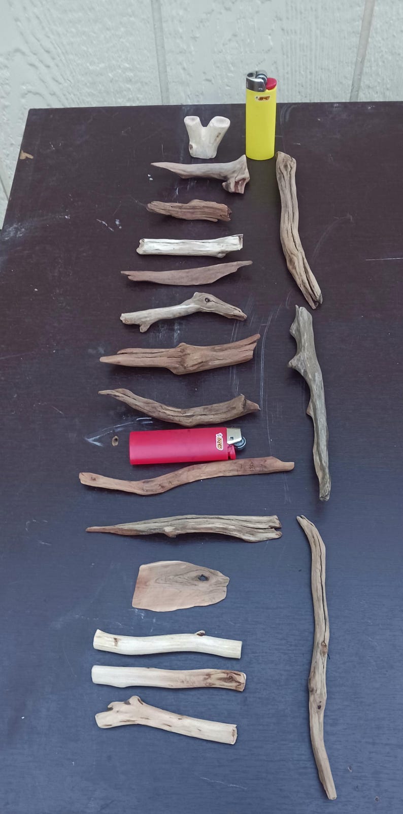 May include: A white ceramic mug with a black handle and the text "But First, Coffee" in a bold, black font. The mug is set against a blurred background, suggesting a cozy setting.