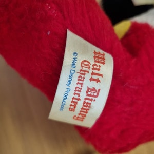 May include: A white tag with red and blue text that reads "Walt Disney Characters" and "&copy; Walt Disney Productions".