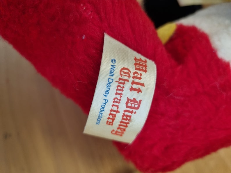 May include: A white tag with red and blue text that reads "Walt Disney Characters" and "&copy; Walt Disney Productions".