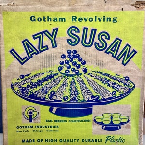 May include: A vintage box for a Gotham Industries Lazy Susan, a revolving serving tray. The box is green and yellow with a blue and white illustration of the Lazy Susan with a bowl of food. The text on the box reads "Gotham Revolving Lazy Susan", "Ball Bearing Construction", "Gotham Industries", "New York - Chicago - California", and "Made of High Quality Durable Plastic".