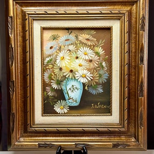 May include: A framed painting of a bouquet of white daisies in a blue and white vase. The painting is signed "J.Z. Wernim".