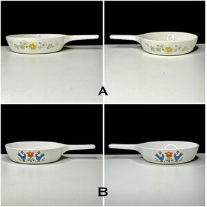 May include: Two vintage white cast iron skillets with different floral patterns. The top skillet has a yellow and white floral pattern. The bottom skillet has a blue bird and flower pattern.