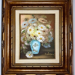 May include: A framed painting of a bouquet of white daisies in a blue and white vase. The painting is signed "J.Z. Wernin".
