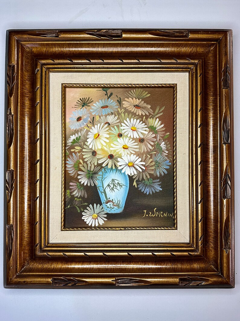 May include: A framed painting of a bouquet of white daisies in a blue and white vase. The painting is signed "J.Z. Wernin".