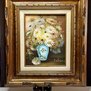 May include: A framed painting of a bouquet of white daisies in a blue and white vase. The painting is signed "J.Z. SERNIN".