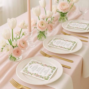 Floral wedding menu card styled on pastel plates with blush flowers and gold flatware for a romantic tablescape.