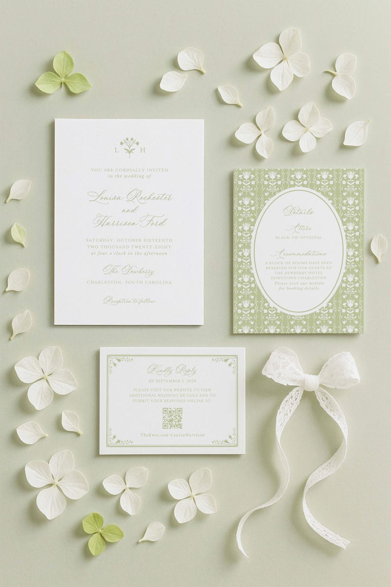 a wedding invitation, a small card, and some white flowers arranged on a light background.